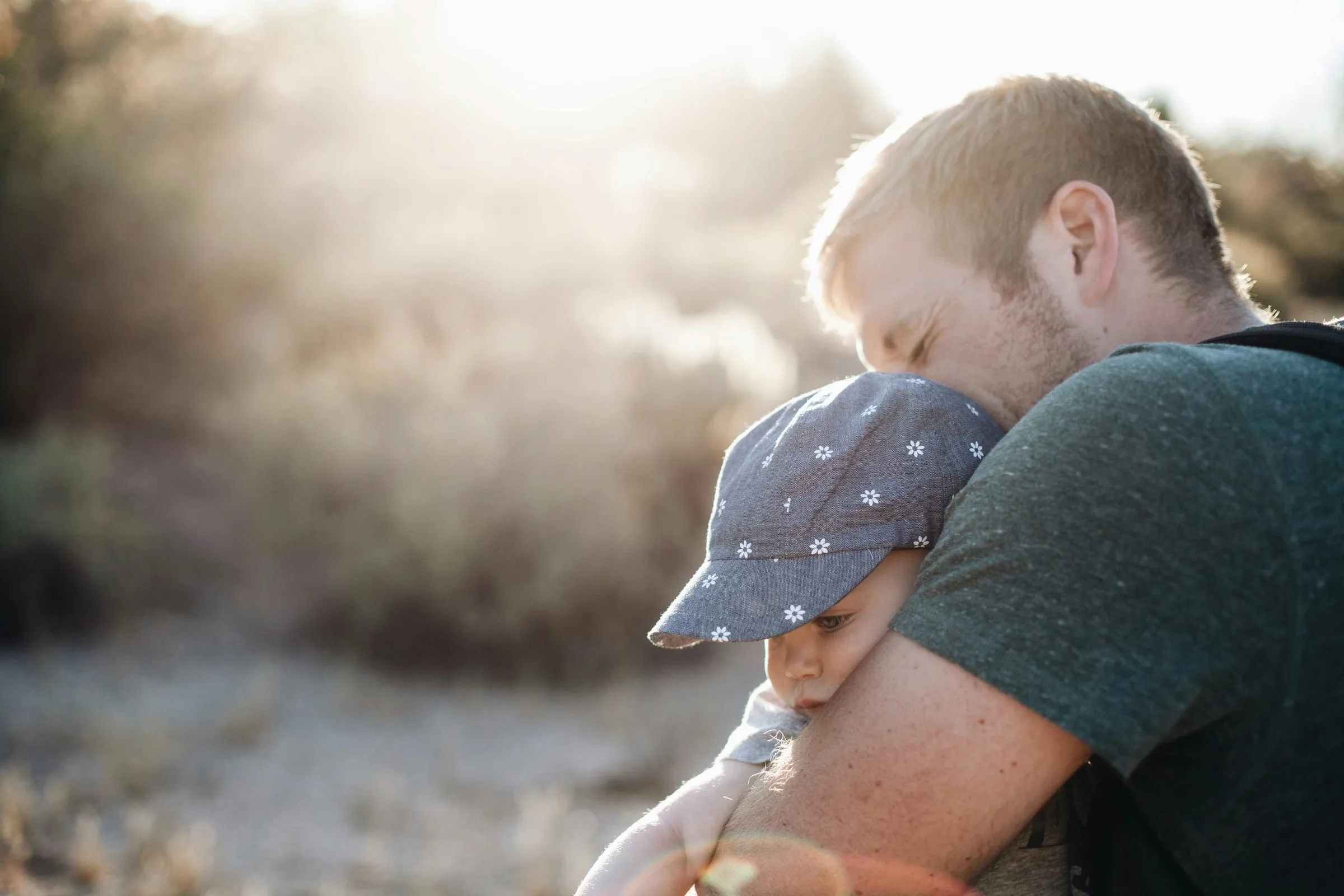 A father holding his son close in the evening sun