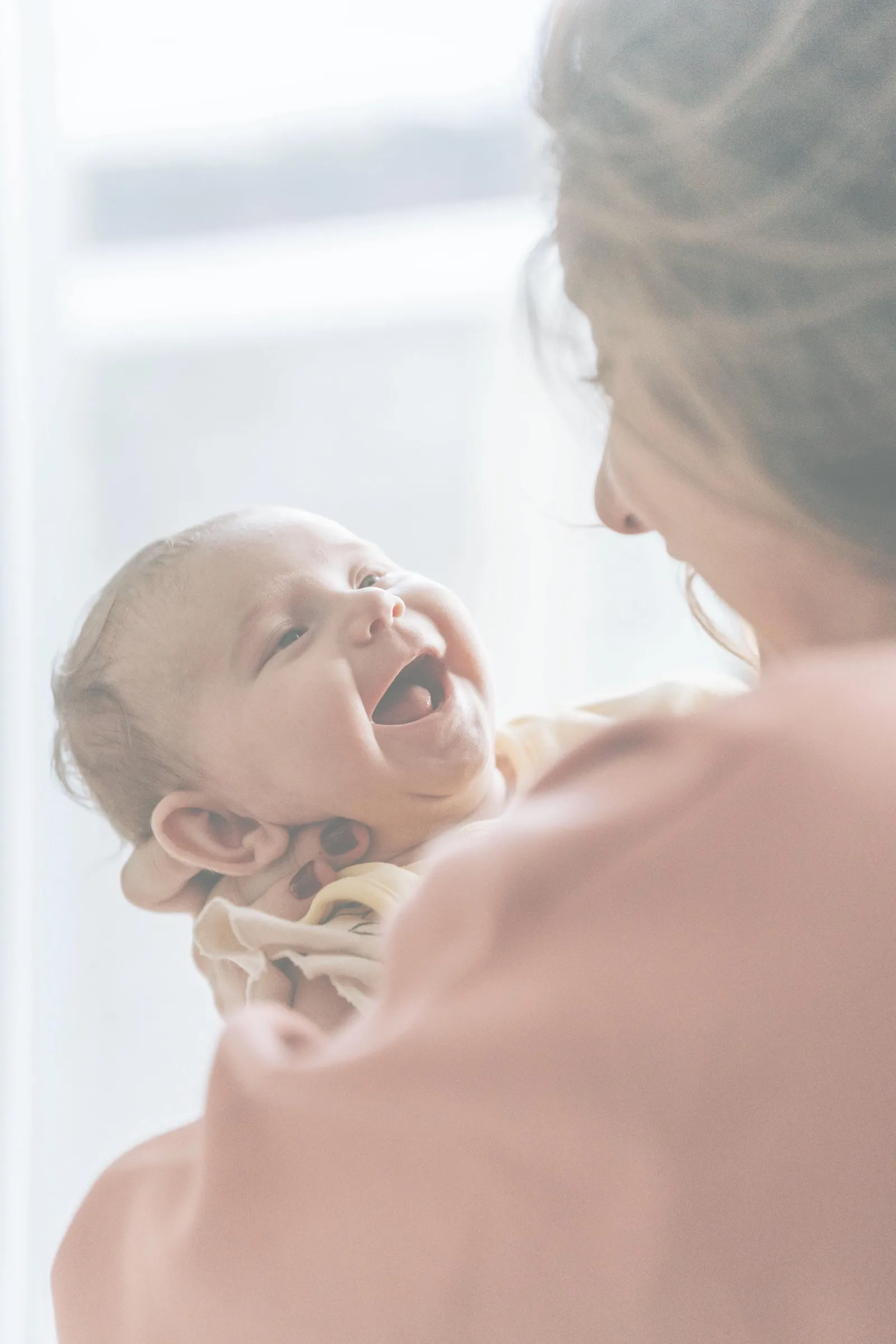 A mother holding her laughing baby